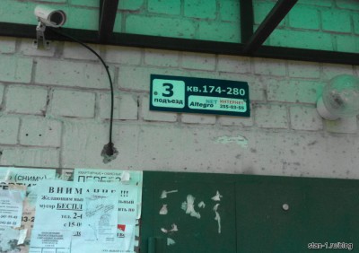 Табличка с номерами квартир и рекламой ШПД над подъездом дома в Воронеже