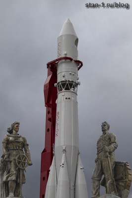Скульптуры, украшающие павильон Космос на ВДНХ на фоне ракеты Р-7